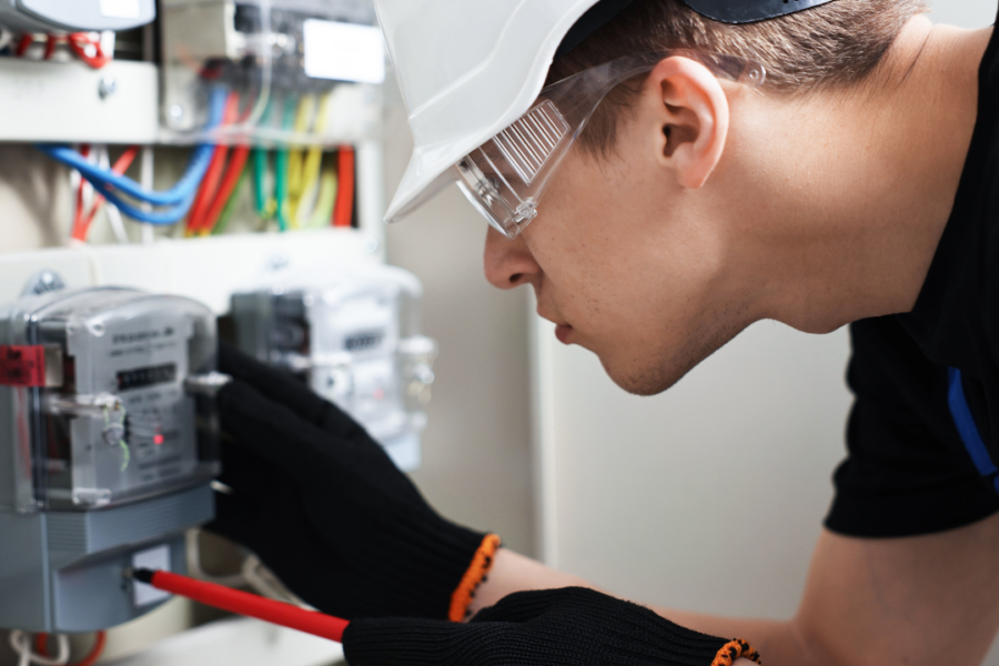 Commercial electrician performing preventive electrical maintenance on building equipment